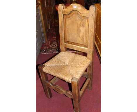 A set of four country stained pine panel back and rush seat dining chairs 