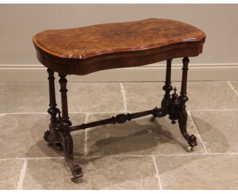 A Victorian burr walnut serpentine card table, the quarter veneered moulded top inlaid with stringing and foliate spandrels, 