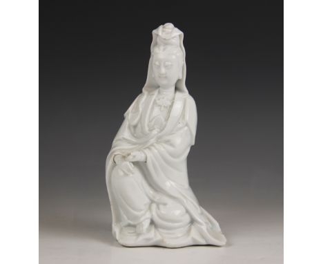 A Chinese porcelain Blanc de Chine figure of Guanyin, early 20th century, modelled seated, draped in robes and holding a scro