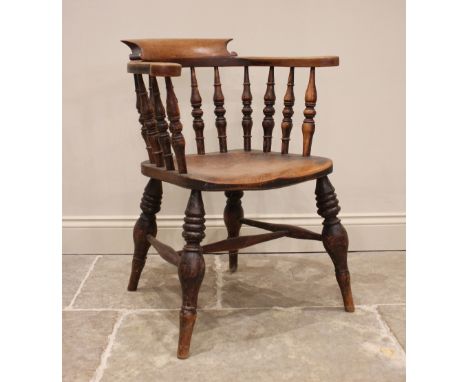 A Victorian elm smokers bow elbow chair, the horse shoe shaped top rail raised upon ring turned baluster spindles, above a sh