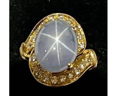 A mid-20th century star sapphire and diamond 18ct gold ring, the central oval cabochon blue sapphire weighing 9.39ct (13.4mm 