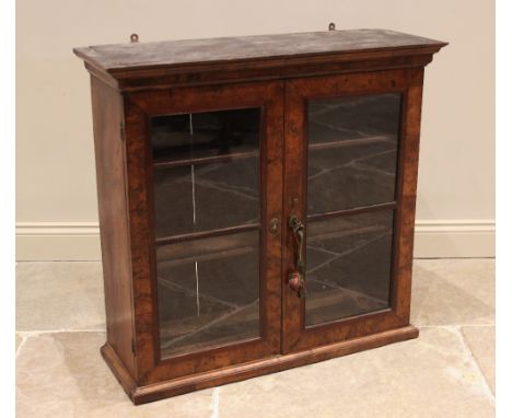 A burr walnut glazed cabinet, early 18th century, the moulded cornice above a pair of glazed and cross banded doors, opening 