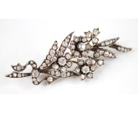 A Victorian diamond floral spray brooch, designed as three flower heads set with old cut diamonds, set upon a foliate surroun