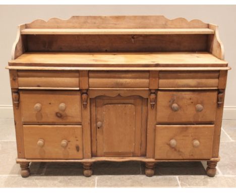 A Victorian pine dresser base, the shaped three quarter gallery with a single shelf above the plank top and three frieze draw