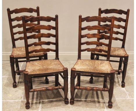A set of four ash ladder back kitchen chairs, 19th century, each with four shaped rungs over an envelope rush seat, raised up