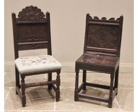 A 17th century carved oak back stool, the carved scroll top rail above a leaf carved back panel and a later upholstered seat 