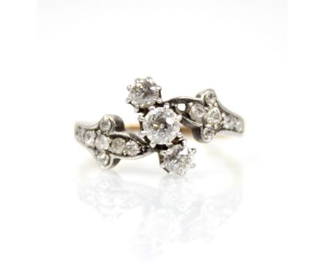 A Victorian diamond foliate ring, comprising a central old cut diamond measuring approximately 3.75mm x 2.7mm, flanked by two