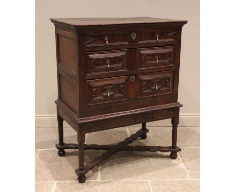 An oak chest on stand, late 17th/early 18th century, the moulded plank top above an arrangement of three long drawers, applie