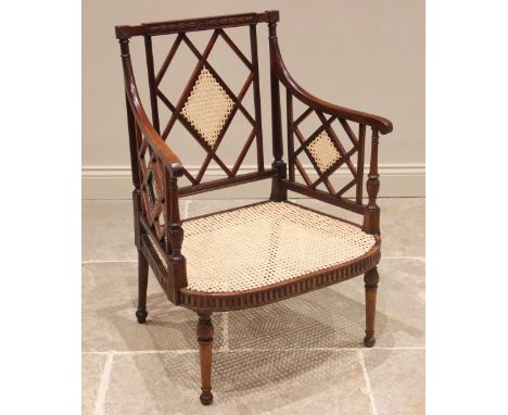 A Regency mahogany open work armchair, the lattice work back panel and sides enclosing the wide bow front rattan seat, above 