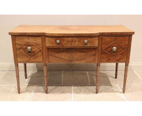 A late George III mahogany breakfront sideboard, the shaped top with a simulated reeded edge above a central oak lined bow fr