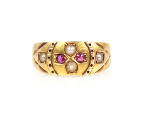 A Victorian ruby and pearl 15ct gold ring, the central floral head set with two half pearls and two mixed cut rubies, with a 