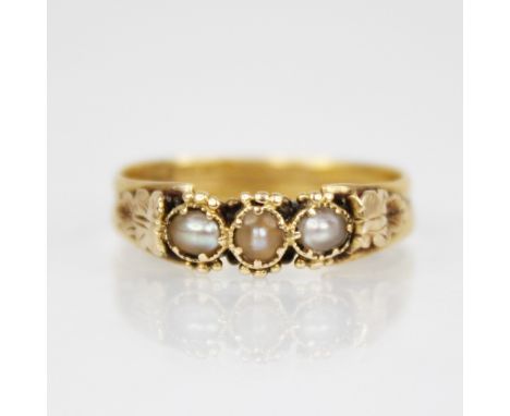 A 19th century pearl set ring, comprising three off-round pearls set to gold coloured beaded borders, continuing to acanthus 