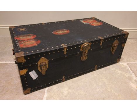 An early 20th century steamer trunk, bearing multiple 'Cunard White Star' labels, applied with rivet detail and gilt metal co