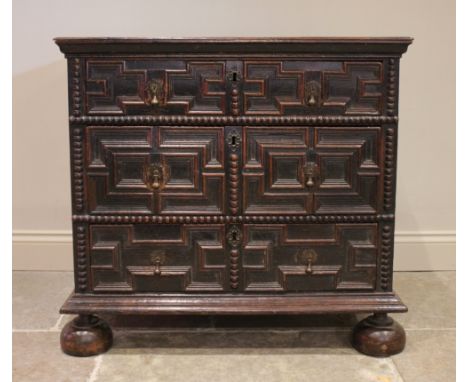 A Jacobean oak chest of drawers, late 17th century, the twin plank top above an arrangement of three long geometrically mould