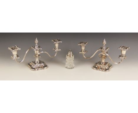 A pair of silver plated three light candelabras, each with shaped square bases and knopped stems with embossed scrolling foli