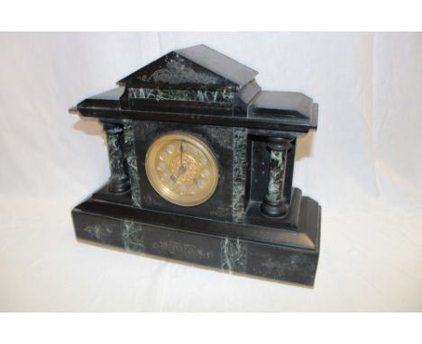 A Victorian mantel clock with gilt circular dial in black slate and marble traditional case