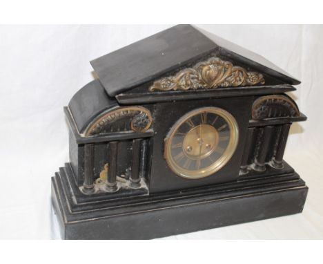 A Victorian mantel clock with decorated circular dial in black slate Venetian-style case