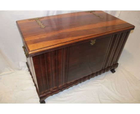 A polished mahogany rectangular trunk with hinged lid and brass hinges and handles on claw and ball feet, 41½" long
