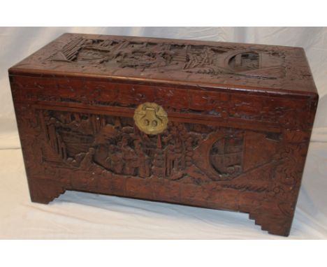 An Eastern carved camphor wood rectangular trunk decorated with various figures and landscapes with brass mounts, internal Ho