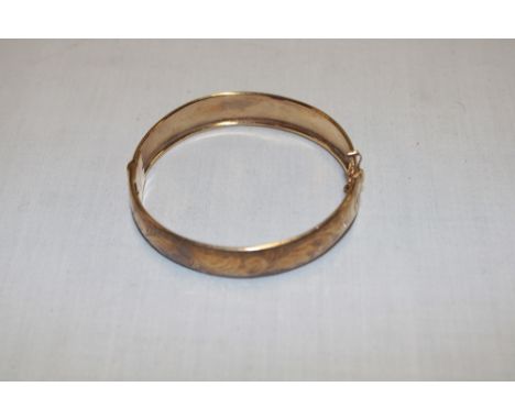 A 9ct gold circular bangle with engraved decoration (15.5g)