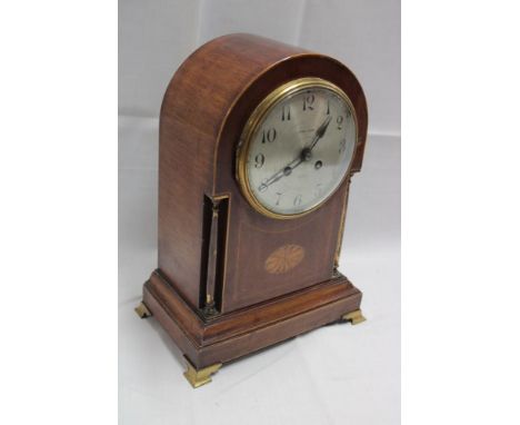A good quality mantel clock with silvered circular dial by Sydney Hanna of Belfast in inlaid mahogany and brass mounted arche