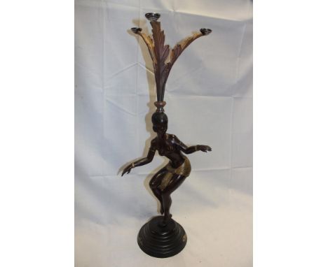 A good quality 20th century bronze and gilt decorated figure of a semi-nude dancing female surmounted by an iron scroll-shape