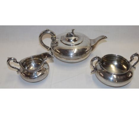 An early Victorian silver three-piece tea set comprising a circular squat-shaped tea pot with scroll handle, the lid decorate