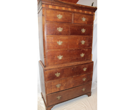 A George III inlaid oak chest on chest, the base with three long graduated drawers, the top with two short and three long dra