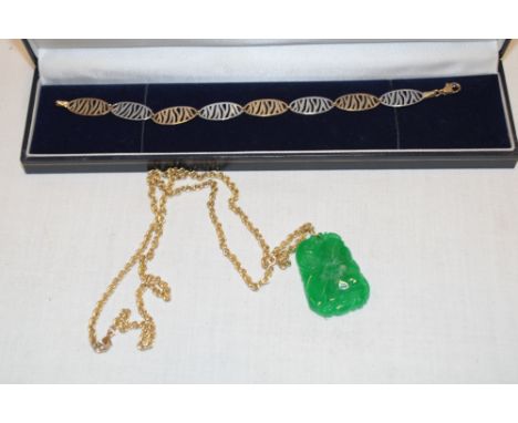A 9ct yellow and white gold bracelet with pierced decoration and a carved jade pendant with 9ct gold chain necklace (2)