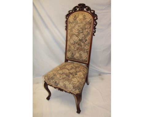 A Victorian carved mahogany hall chair upholstered in floral tapestry on scroll legs