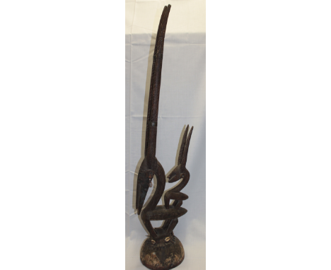 A carved wood tribal fertility head-dress from the Bamana Tribe of Mali in the form of a horned animal with similar smaller f