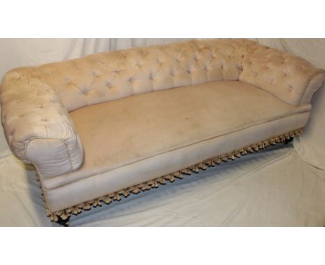 An old Chesterfield sofa upholstered in buttoned draylon on turned legs with castors, 82" long