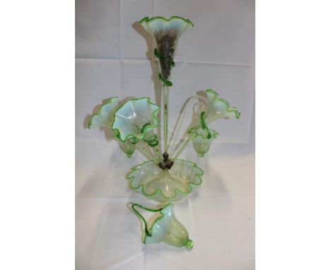 A Victorian green tinted glass epergne/table centre with four tapered trumpet spills and two glass canes supporting baskets (