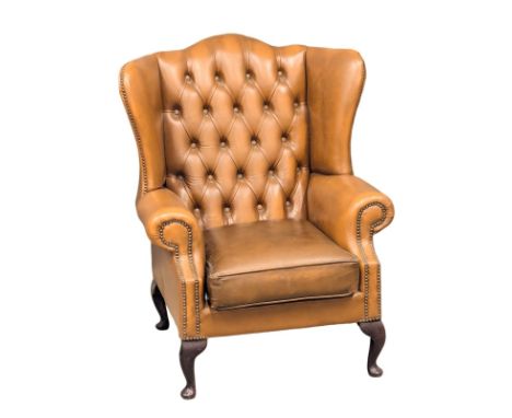 A Georgian style deep button leather wingback armchair.