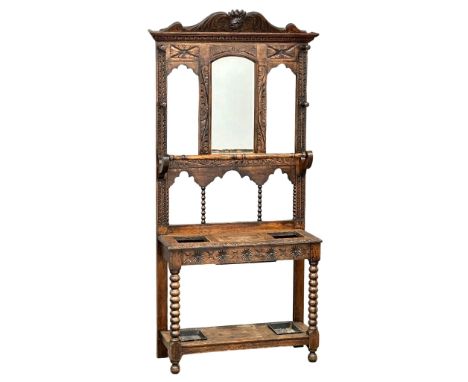 A large Late 19th Century Victorian carved oak hallstand. With bobbin turn supports, front rail and man of the forest decorat