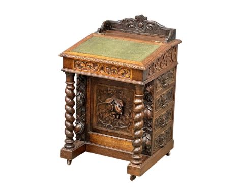 A 19th Century Victorian carved oak Davenport desk, with leather top and Man of the Forest decoration. Circa 1880. 61x58x96cm