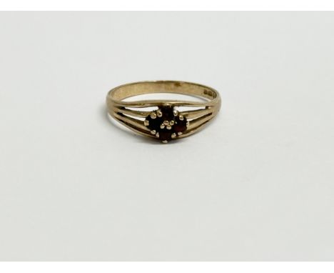 A ladies 9ct gold ring with garnets. 2.4 grams. Size R.      (11)