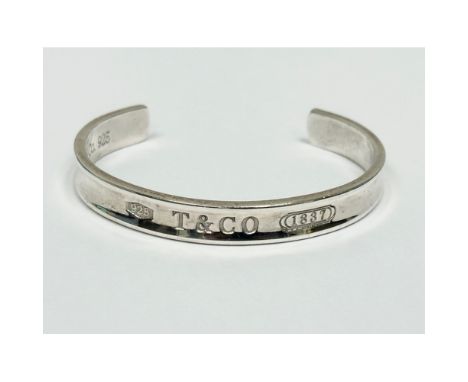 A Tiffany &amp; Co silver bangle with box and case.