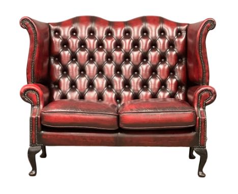An ox-blood deep button leather 2 seater wingback sofa. 136cm. (5)