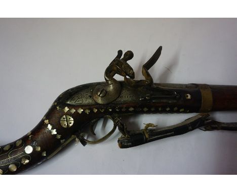 An Indian Flintlock Gun, Signed Wilson 1801, Having a metal ramrod, walnut butt and stock, the butt is profusely inlaid with 