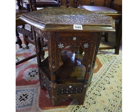 A Burmese Carved Octagonal Table, circa early 20th century, Decorated with mother of pearl roundels, 53cm high, 54cm wide 