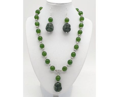 A Tibetan silver and green jade necklace and earrings set with hand carved smiling Buddha head pendants. Necklace length: 50c