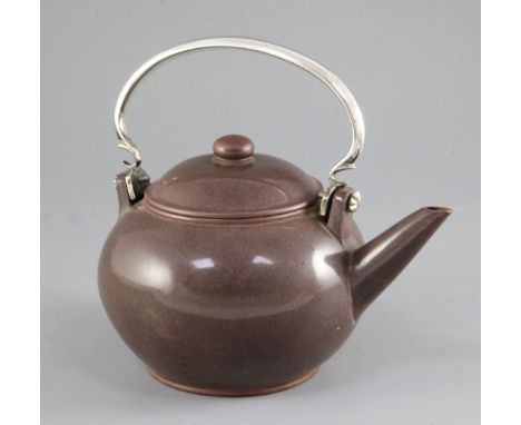 A Chinese Yixing pottery globular teapot and cover, 19th century, with silver arched hanging handle, incised marks to base an