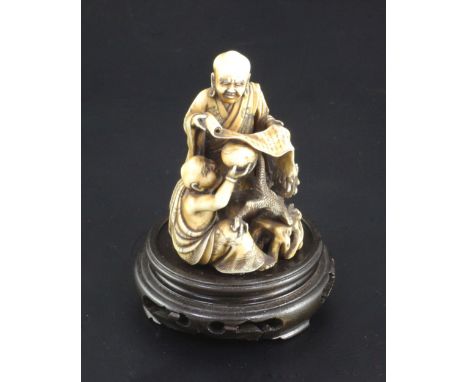 A Japanese ivory okimono netsuke of Handaka Sonja invoking a dragon with another rakan, Meiji period, standing and holding a 