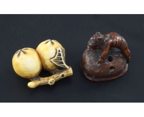 Two Japanese netsuke, 19th century, the first carved as two persimmon fruit in ivory, two character signature, 4.1cm and the 