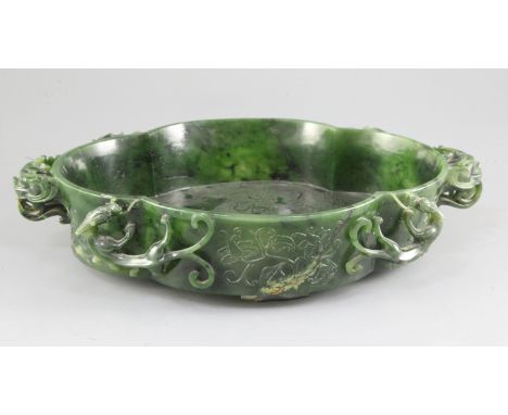 A large Chinese spinach green jade quatre-lobed bowl, Qianlong mark, the exterior carved in high relief and openwork with fou