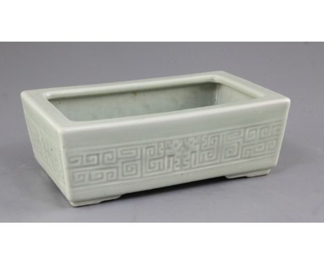 A Chinese celadon glazed narcissus jardiniere, impressed Qianlong mark, 19th century, the frieze moulded with archaistic scro