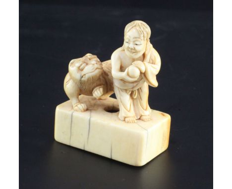 A Japanese ivory netsuke of Binzuru rakan and a tiger, Edo period, standing on a rectangular seal base, height 4.8cm