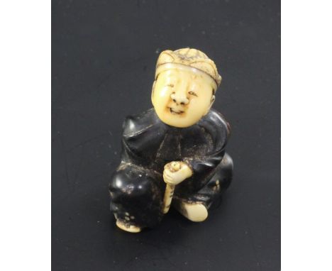 A Japanese wood, lacquer and ivory netsuke, Meiji period, modelled as a seated boy holding a fan and a flute, unsigned, 4.2cm