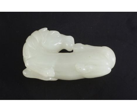 A Chinese white jade figure of a recumbent horse, 18th / 19th century, the stone of good even tone with occasional brighter i